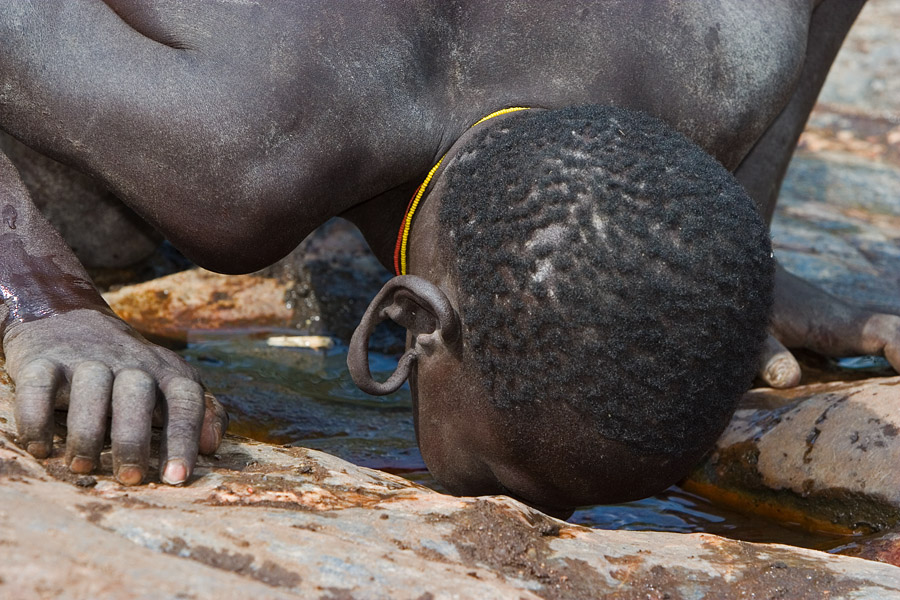 69   Surma boy drinking from the holy Magologni hot springs